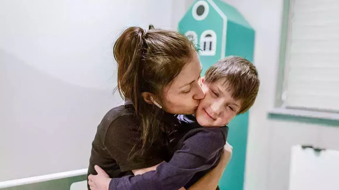 mother and son with Rothmund-Thomson syndrome hugging each other