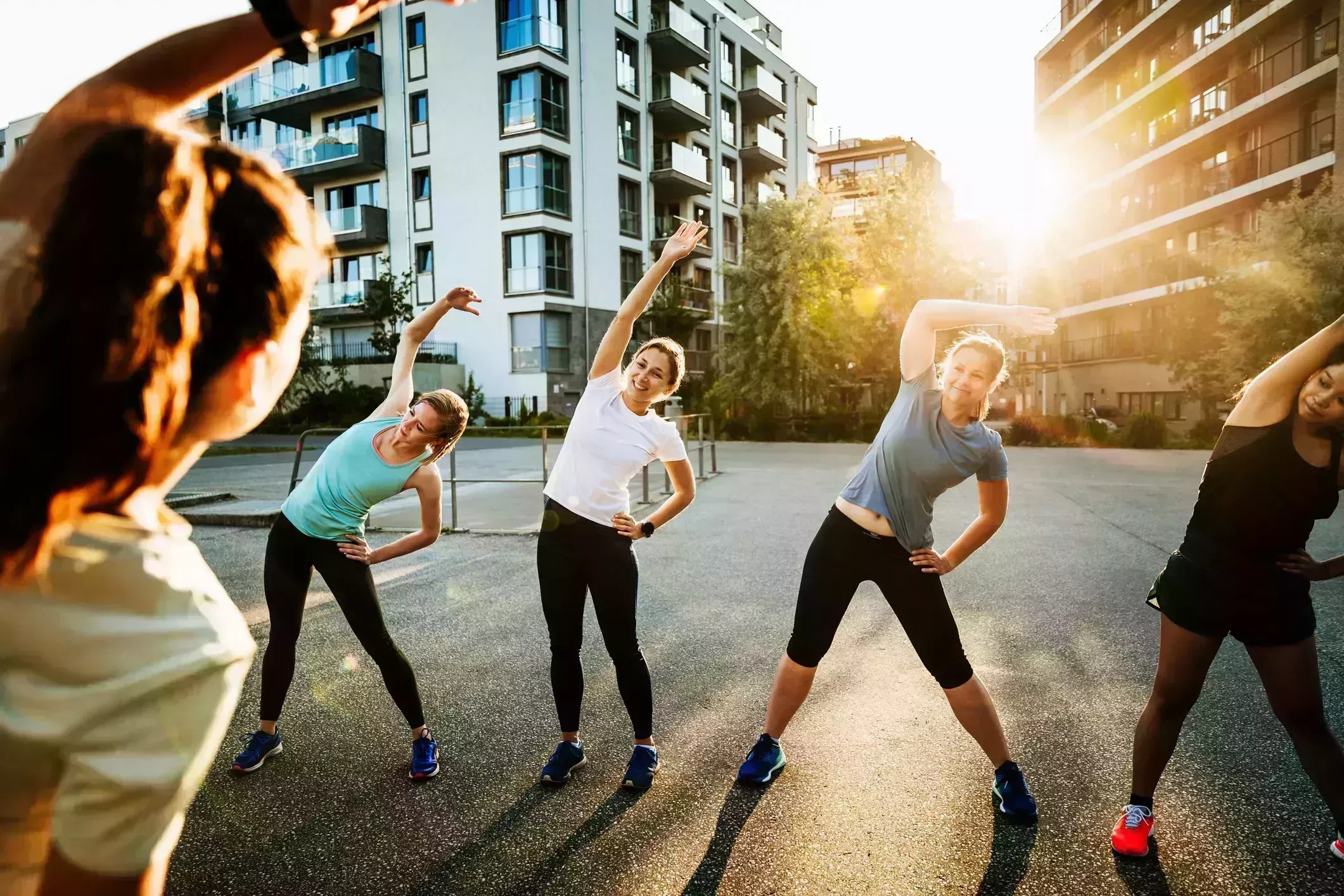 morning stretches – four women being led by another doing side stretch outside