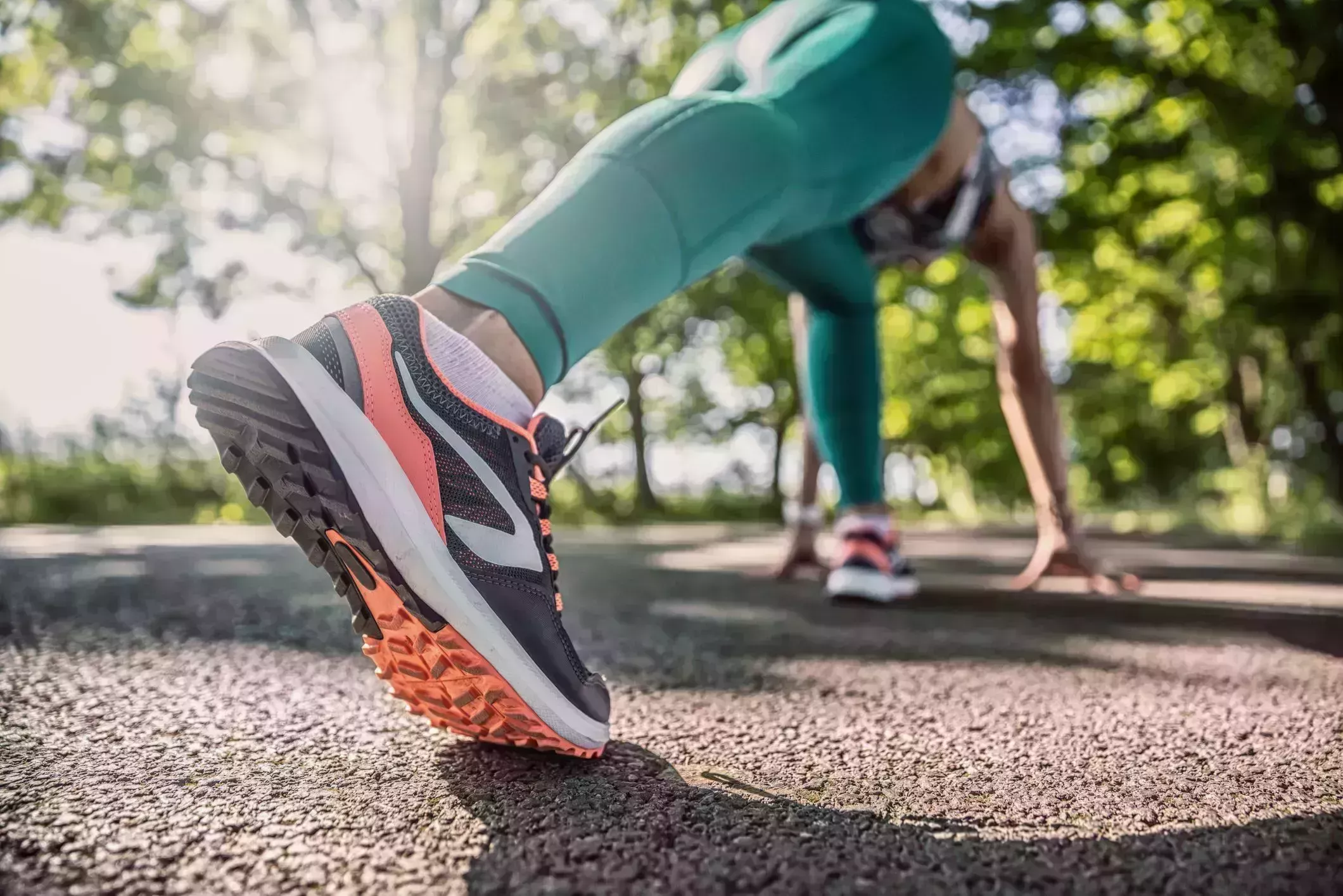 morning stretches – woman in workout clothes doing a runners lunge and shot from perspective of her outstretched leg